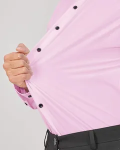 Vue détaillée d'une chemise rose extensible pour hommes montrant l'élasticité du tissu