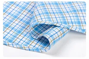 Close-up detail of the professional wrapped hem on a blue and white checkered cotton shirt.