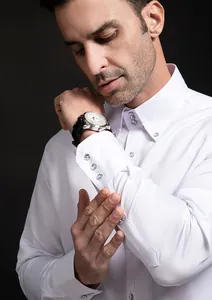 Detailed view of white men's dress shirt cuffs featuring elegant crystal button accents