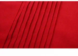 Close-up of fine stitching and pleated details on a red wedding tuxedo shirt