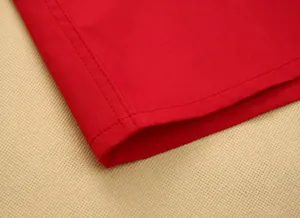 Close-up detail showing the double-curved hem and stitching on a vibrant red men's shirt