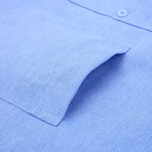 Dettaglio camicia Oxford blu uomo a maniche lunghe con tasca e trama del tessuto