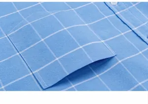 Gros plan d'une poche de chemise Oxford à carreaux bleus avec coutures fines et texture.