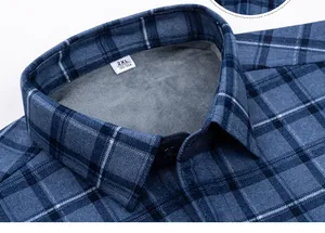 Dettaglio ravvicinato di camicia a quadri blu con morbida fodera in pile e colletto.