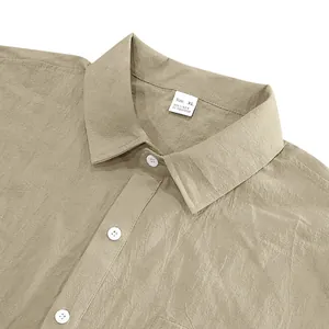 Detailopname van de kaki linnen overhemdkraag met stoftextuur en maattab label