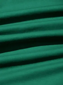 Gros plan montrant la texture douce et les plis du tissu en pur coton vert pour les t-shirts