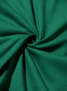 Gros plan macro d'un tissu en coton vert foncé montrant une texture jersey douce