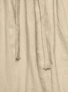 Close-up of breathable beige linen fabric and drawstring detail on casual pants