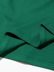 Vue détaillée de la couture à double aiguille sur l'ourlet d'un T-shirt en coton vert