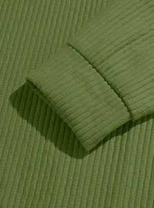 Macro view showing the detailed olive green ribbed knit cuff of a winter sweatshirt