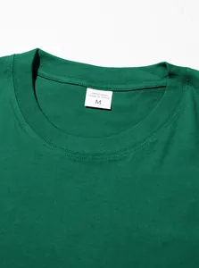 Détail du col d'un t-shirt en coton vert avec étiquette de taille M bien visible.