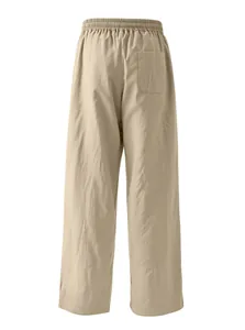 Back view of men's loose linen pants featuring elastic waist and rear pocket detail.