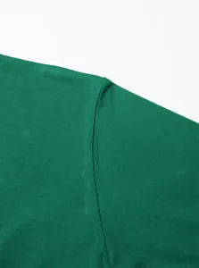 Vue détaillée de la couture d'épaule et texture du tissu d'un t-shirt en coton vert