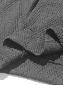 Close-up detail of black jacquard knit fabric showing chevron texture and stitching