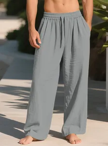 Close-up view of men's loose casual linen trousers with drawstring waist and pockets in grey