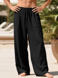 Close-up of men's loose black linen pants showing breathable texture and drawstring waist