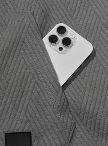 Close-up detail of grey jacquard knit fabric showing pocket functionality and texture.
