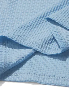 Close-up detail of breathable honeycomb texture fabric for light blue men's polo shirt.