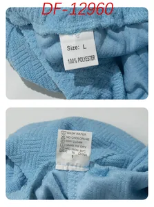 Detail van het waslabel en het maatlabel op getextureerde blauwe badstof jacquard stof