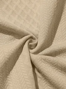 Detalle macro de tela de punto jacquard beige con textura de patrón de diamantes.