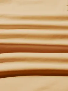 Close-up macro detail showing the soft texture and weave of the beige sweatshirt fabric