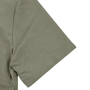 Detail view of the stitching and linen fabric texture on an olive green men's short sleeve shirt