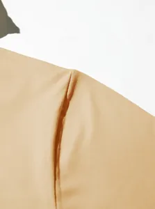 Close-up macro view of the premium stitching and fabric texture on a beige men's Henley sweatshirt