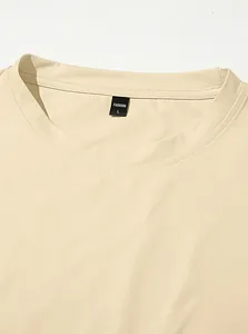 Detail view of the crew neck and size tag on a beige men's sports T-shirt