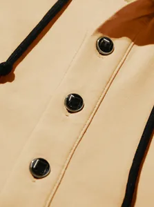Macro detail of the Henley neck and black buttons on a premium beige hooded sweatshirt.