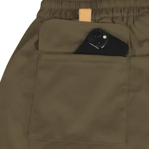 Detailopname van de achterzak van een olijfgroene cargoshorts met smartphone voor maat