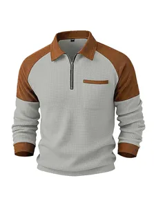 Detail view of men's waffle knit polo shirt with half-zip and contrast brown sleeves.