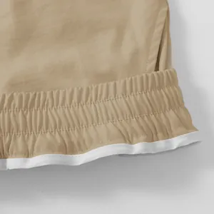 Close-up detail van de kaki cargo korte broek met elastische tailleband en wit accent