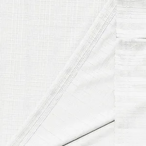 Close-up of white slub textured fabric showing high-quality stitching on a men's T-shirt.