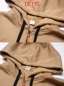 Close-up van de kraag van een camel hoodie met rits, maat L label en oranje trekker