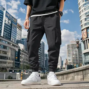 Detail view of men's black multi-pocket cargo pants with elastic cuffs for outdoor wear