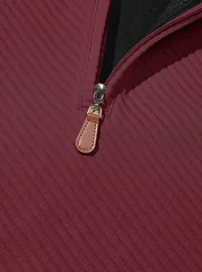 Primo piano della cerniera in metallo e della texture jacquard a coste sulla felpa bordeaux