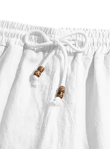Dettaglio ravvicinato della vita di pantaloncini bianchi con coulisse e perline in legno