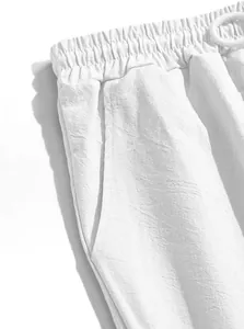 Dettaglio di pantaloncini bianchi estivi leggeri con elastico in vita e trama tasca