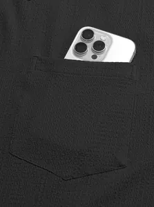 Close-up detail of a men's black shirt pocket showing the textured waffle fabric style