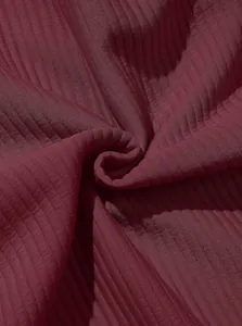 Macro vista del pregiato tessuto jacquard a coste bordeaux per felpe casual da uomo.