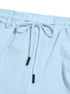 Close-up detail of drawstring elastic waistband on light blue men's beach shorts