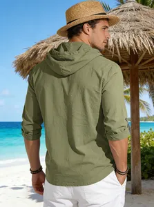 Vista posteriore di una maglia con cappuccio verde oliva da uomo in una spiaggia tropicale.