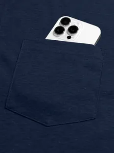 Detail of navy blue polo shirt chest pocket showing storage capacity with a phone