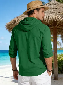 Vista posteriore di uomo con maglia casual verde con cappuccio in cotone in spiaggia