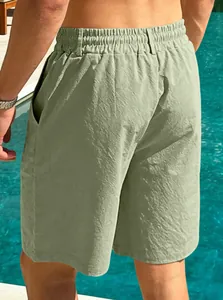 Rear view of breathable men's sage green cotton linen beach shorts shown in poolside setting