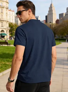 Back view of a navy blue short-sleeved Henley shirt on a male model in an urban park