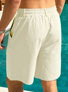 Rear view detail showing breathable men's cream cotton linen beach shorts by a pool