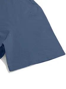 Gros plan d'une manche de T-shirt bleu en coton et lin montrant la texture du tissu.