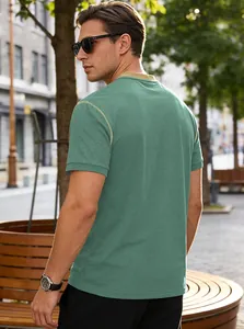 Detailed back view of a stylish men's green casual t-shirt in an urban setting