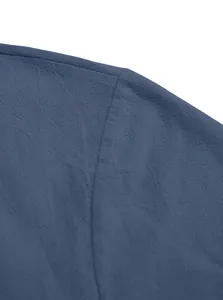 Gros plan sur le tissu respirant en coton et lin et la couture de l'épaule du t-shirt bleu